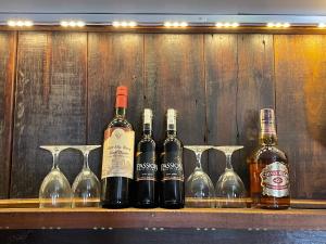 a row of wine bottles and wine glasses on a shelf at Homestay Phong de Pêche in Ấp Tân Bình (1) +43 photos