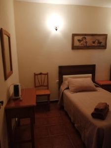 1 dormitorio con 1 cama, 1 mesa y 1 lámpara en Casa José, en Tajace de Abajo