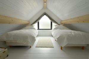 Duas camas num quarto com uma janela em Vakantiehuisje Buuf in de Brabantse natuur em Schijndel