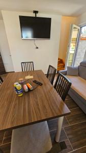 a dining room table with chairs and a television on the wall at Office Escape - holiday home in Terme Čatež in Brežice