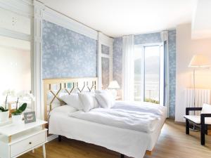 - une chambre avec un lit blanc et une grande fenêtre dans l'établissement La Caletta Hotel Bolognese, à Brenzone