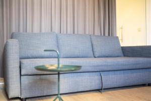 ein blaues Sofa mit einem Tisch im Wohnzimmer in der Unterkunft Smartflats - Meir Antwerp in Antwerpen