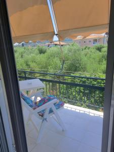 a chair and a table on a balcony with a view at Stathis Rooms in Skafidia