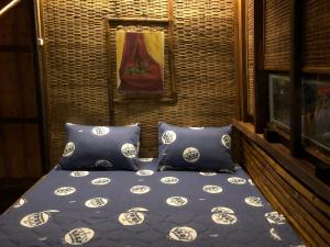 - un lit avec des oreillers bleus et blancs dans l'établissement Homestay Phong de Pêche, à Ấp Tân Bình (1)