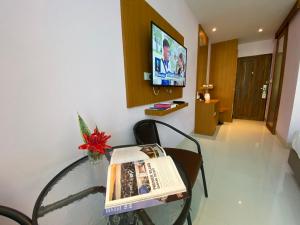 - une table en verre avec un journal dans la chambre dans l'établissement A Hotel Simply, à Chiang Saen