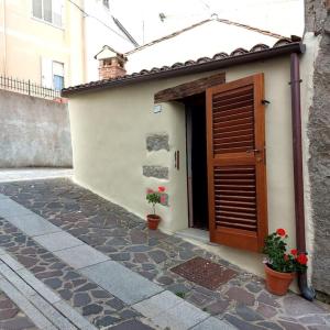 een gebouw met een deur en twee planten ervoor bij Casa storica Austis, Sardegna in Austis