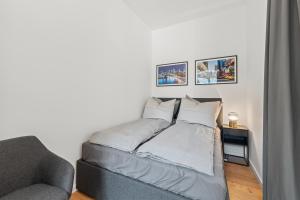 a bed in a room with a couch and pictures on the wall at The Straßburger, stylish 3 BR apartment in Mitte, group & family friendly, 4- 6 Guests in Berlin