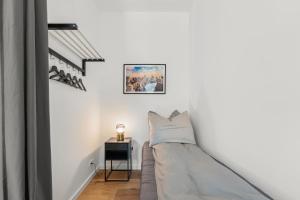 una piccola camera con un letto su una parete bianca di GreatStay - Straßburger Str 18, stylish 3 BR apartment in downtown Berlin a Berlino