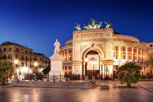 Un gran edificio con una estatua delante. en Merlo House - Inside the historical center, en Palermo