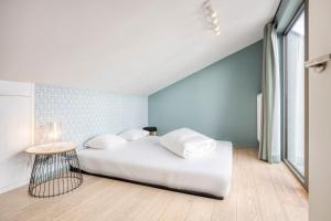 a bedroom with a white bed and a blue wall at Smartflats - Rubens Antwerp in Antwerp