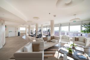 un soggiorno con mobili bianchi e tapis roulant di Laguna Park Hotel 4Superior a Bibione