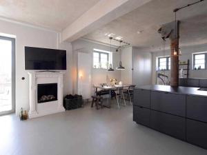 a living room with a fireplace and a dining room at Ohlerich Speicher App_ 17 in Wismar