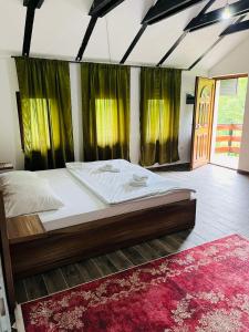 a large bed in a bedroom with green curtains at Azra River View House in Bihać