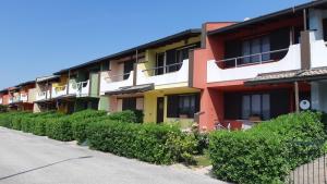 a row of colorful apartment buildings on a street at Villa a schiera con uso piscina in Aprilia Marittima