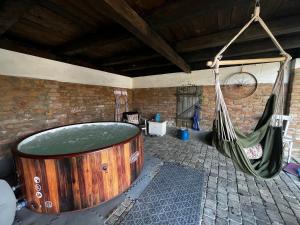 a large wooden tub with a hammock in a room at Frissítőpont Vendégház in Kisszékely