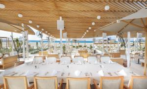 a large white table and chairs in a restaurant at Cleopatra Luxury Resort Sidi Heneish - North Coast in Marsa Matruh