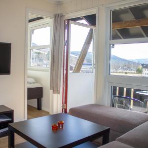 ein Wohnzimmer mit einem Sofa und 2 Fenstern in der Unterkunft Hafjell Alpinlandsby Pluss in Hafjell