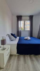 1 Schlafzimmer mit 2 Betten mit blauer Bettwäsche und einem Fenster in der Unterkunft La casita de Lucentum in Alicante