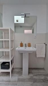 ein weißes Badezimmer mit einem Waschbecken und einem Spiegel in der Unterkunft La casita de Lucentum in Alicante