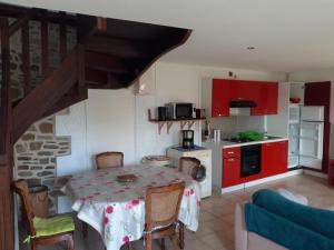 a kitchen with a table and a kitchen with red cabinets at gite Conan in Plourivo