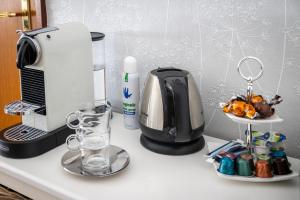 um balcão de cozinha com comodidades para preparar café e um liquidificador em B&B Eikendreef em Haelen