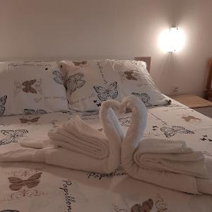 zwei Schwäne aus Handtüchern auf einem Bett in der Unterkunft Apartments Kaić 1045 in Pula