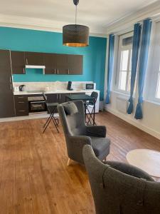 - un salon avec des murs bleus, une table et des chaises dans l'établissement Résidence Pont à l'Herbe, à Douai