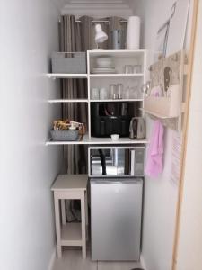 una pequeña cocina con estanterías blancas y nevera en Worcester the Karoo Guest Room, en Worcester