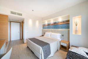 a bedroom with a white bed and a painting on the wall at Laguna Park Hotel 4Superior in Bibione