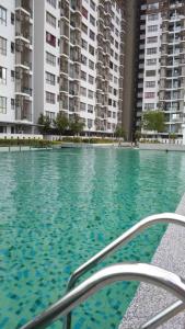una piscina de agua con edificios en el fondo en Sg Buloh Cozy Apartment WiFi & Netflix (Rahman Putra) (6pax), en Sungai Buloh