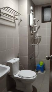 y baño con aseo, ducha y lavamanos. en Sg Buloh Cozy Apartment WiFi & Netflix (Rahman Putra) (6pax), en Sungai Buloh