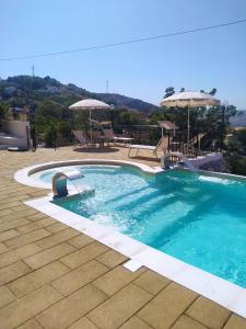 a swimming pool with two chairs and umbrellas at B&B Vento di Scirocco in Favara