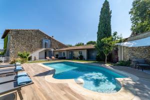 a swimming pool in front of a house at Mazet Pierre de Vers - Le Mas des Olivers Nîmes in Nîmes