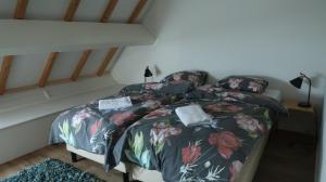 een slaapkamer met een bed met een bloemenbed bij De Galerie - Landgoed Rijckholt in Geersdijk