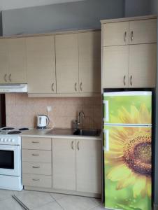 eine Küche mit einem Kühlschrank, auf dem eine Sonnenblume gemalt ist in der Unterkunft Sunflower in Kissamos