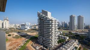 a tall building in a city with tall buildings at Luxury Apartments Blue Wave in Ashdod