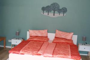 ザンクト・アルデグントにあるFerienwohnung Jattaのベッドルーム1室(オレンジのシーツと枕2つ付)