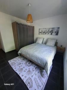 a bedroom with a bed and a rug on the floor at Appt 2 pièces paisible : Confort & Parking inclus! in Savigny-le-Temple