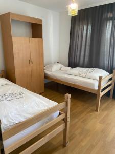 a room with two beds and a cabinet in it at Hostel Heimli in Prishtinë
