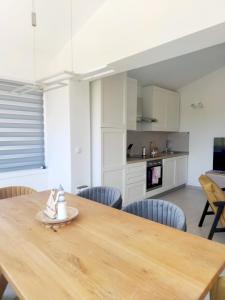 cocina y comedor con mesa de madera y sillas en Apartment Betty, en Labin