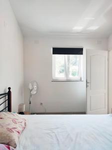 een witte slaapkamer met een bed en een raam bij Apartment Betty in Labin