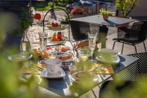 - une table avec des assiettes de nourriture et de boissons dans l'établissement Rebenheim, à Termeno
