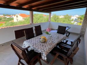 a dining table and chairs on a patio at Apartments Pende in Rab