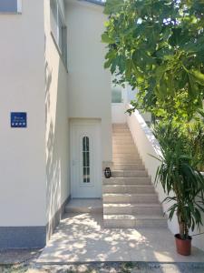 a stairway leading to a white building with a white door at Apartment Betty in Labin