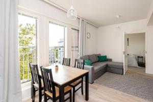 a living room with a table and chairs and a couch at Kotimaailma Apartments Loimu V in Oulu