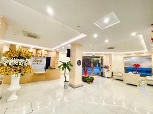 a lobby with a waiting area with flowers in a building at DREAM HOTEL Bắc Ninh in Hòa Ðình