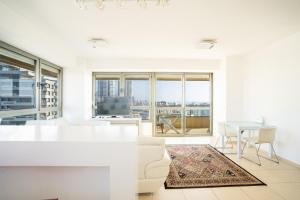 a white living room with a view of a city at Luxury Apartments Blue Wave in Ashdod
