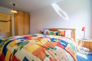 a bedroom with a colorful quilt on a bed at Casa Cresta A31 in Arosa