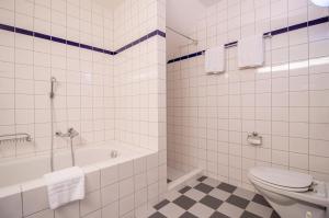 a white bathroom with a tub and a toilet at Casa Cresta A31 in Arosa