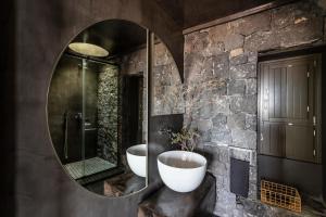 baño con 2 lavabos y espejo grande en Serra Exclusive Suites, en Akrotiri